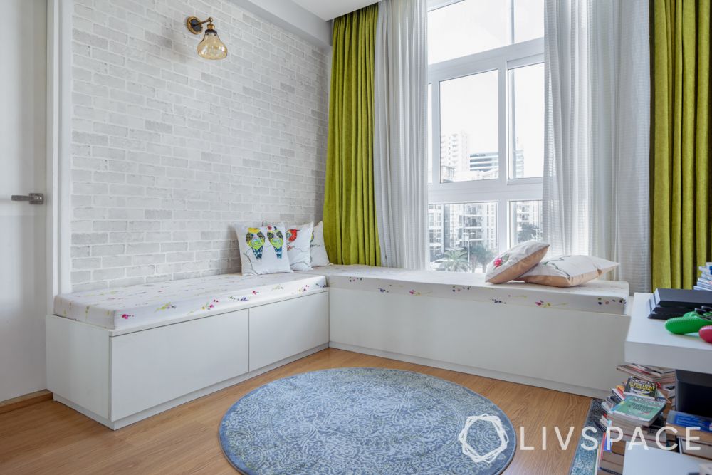 white exposed brick wall-green curtains-window seating