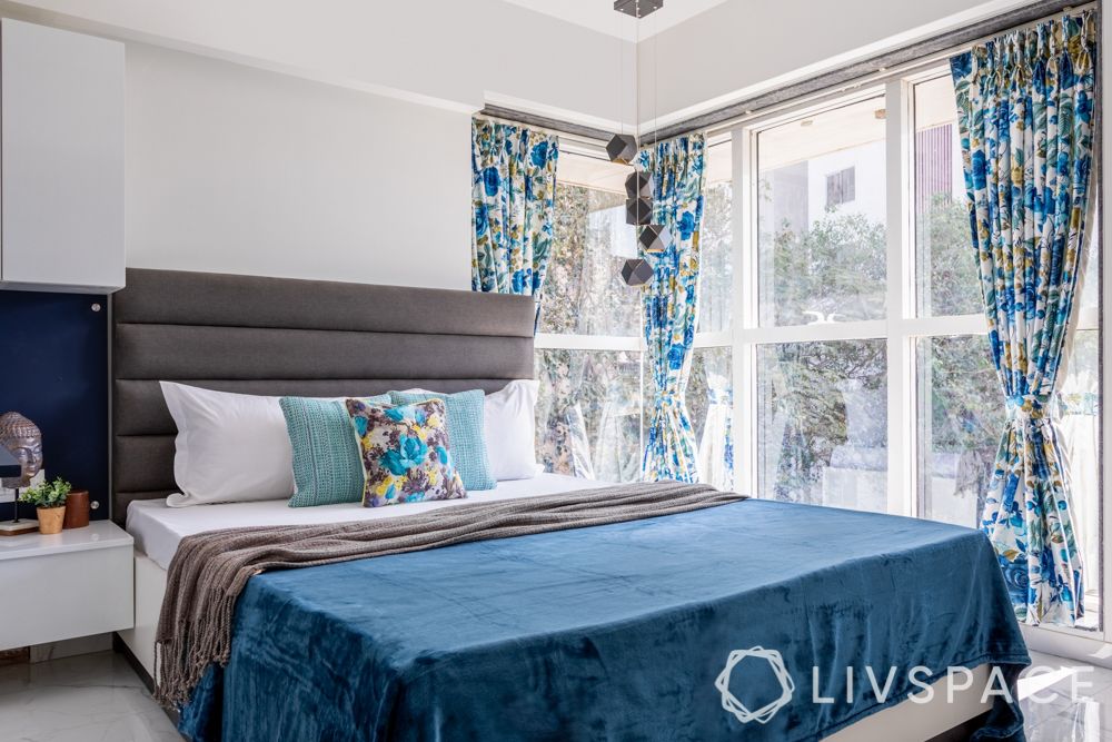blue bedroom-floral curtains-grey headboard