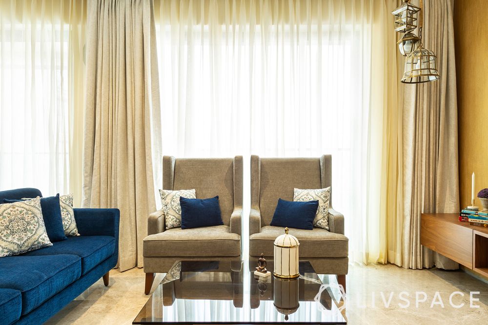 blue sofa-arm chairs-neutral curtains-pendant lights