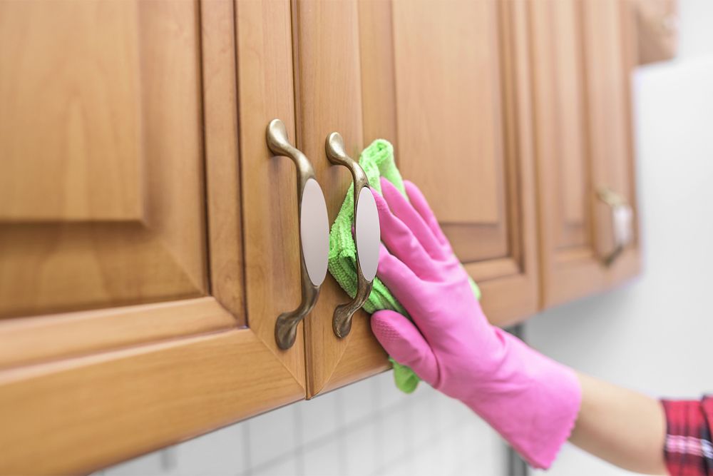 clean-kitchen-cabinet-hardware-gloved-hand-cleaning-with-cloth