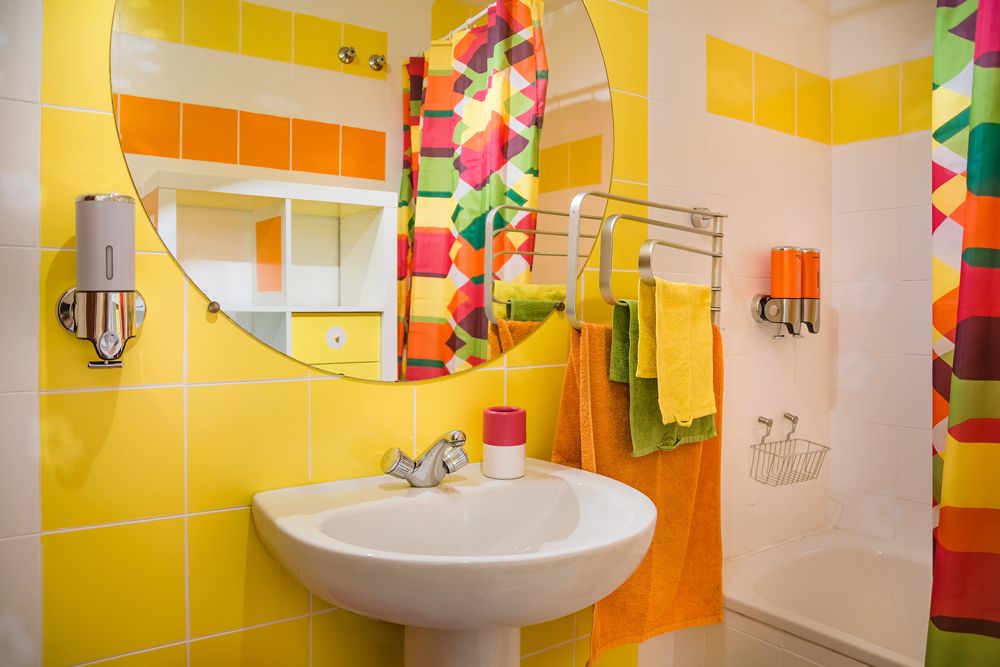 bathroom design India-Bohemian style-yellow walls-colourful shower curtain-statement mirror