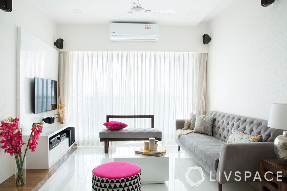 minimalist house-white interiors-grey sofa-pink pouffe