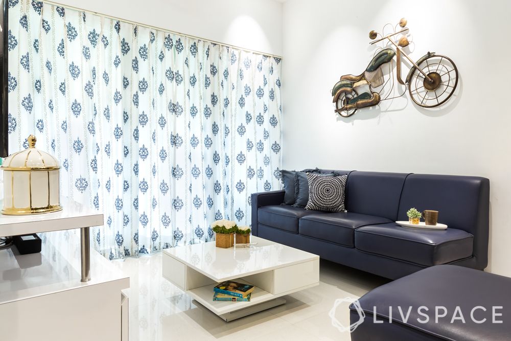 living-room-ideas-light-statement-piece-bike-blue-couch-white-walls-coffee-table