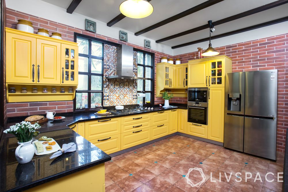 open-kitchen-india-yellow-red-floor-exposed-brick-wall
