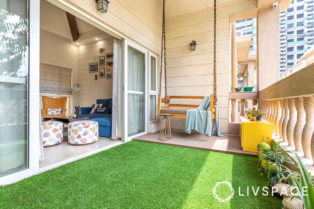sliding-glass-main-door-design-in-balcony-with-faux-grass-and-swing