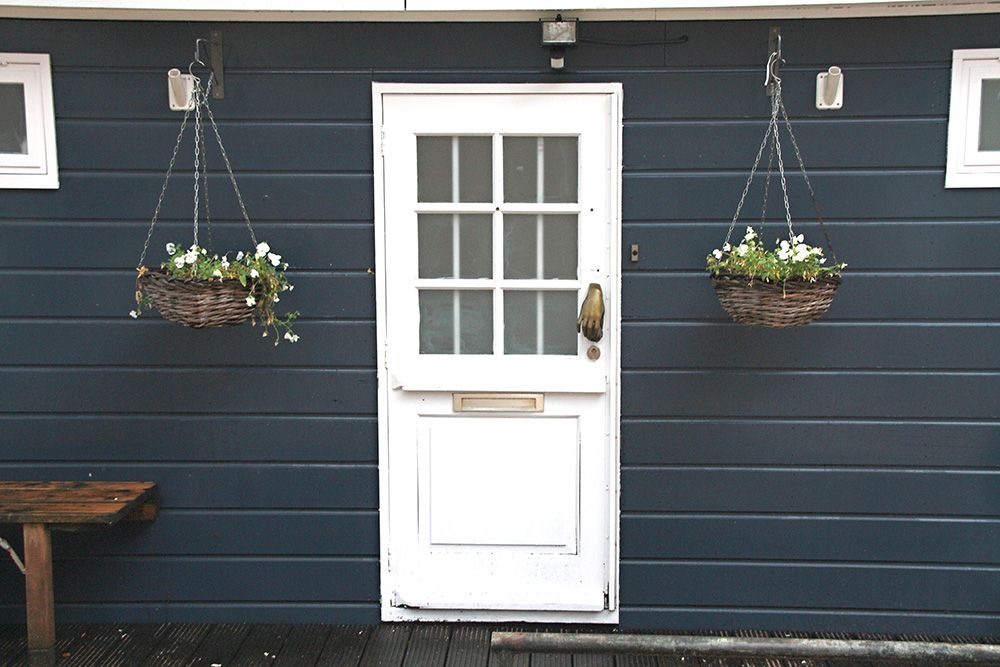 white-main-door-entrance-design-for-flats-with-hanging-planters