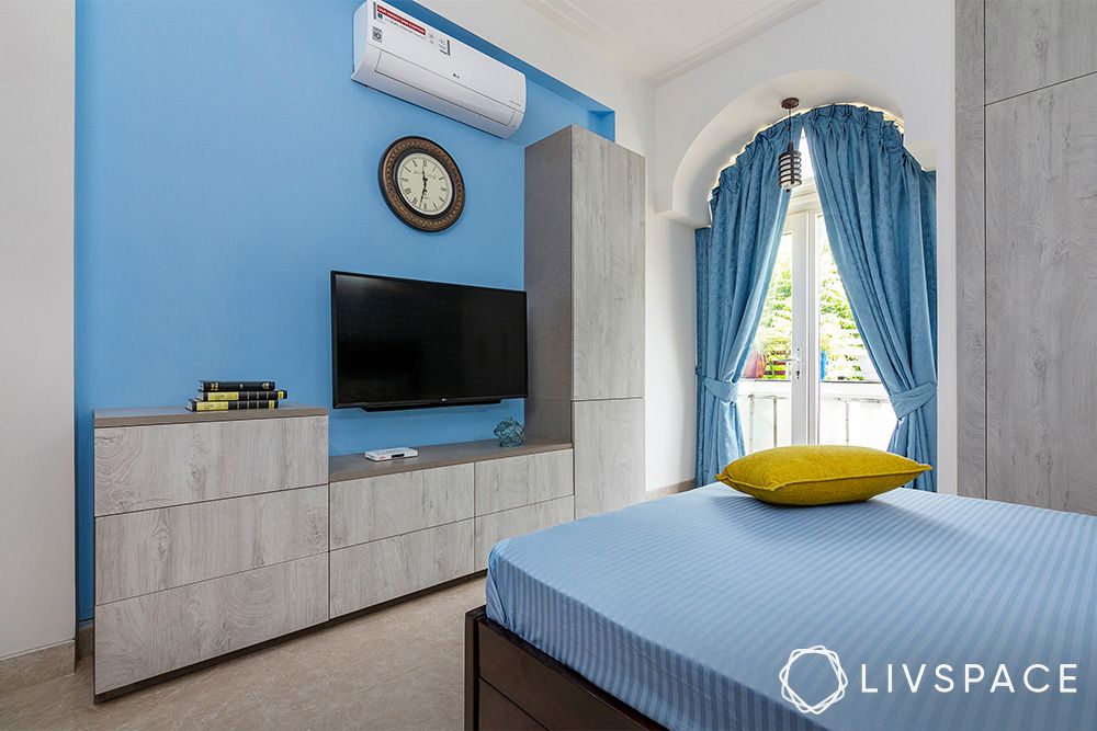 blue-bedroom-with-arched-window-and-textured-TV-unit