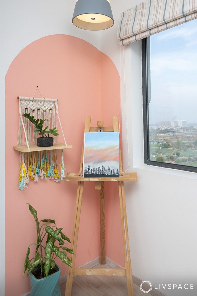 corner-with-arch-and-pastel-pink-accent-wall-with-macrame-wall-unit