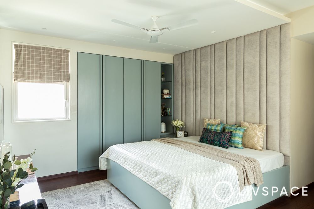 handleless-blue-cupboard-in-bedroom-with-beige-fabric-headboard-wall