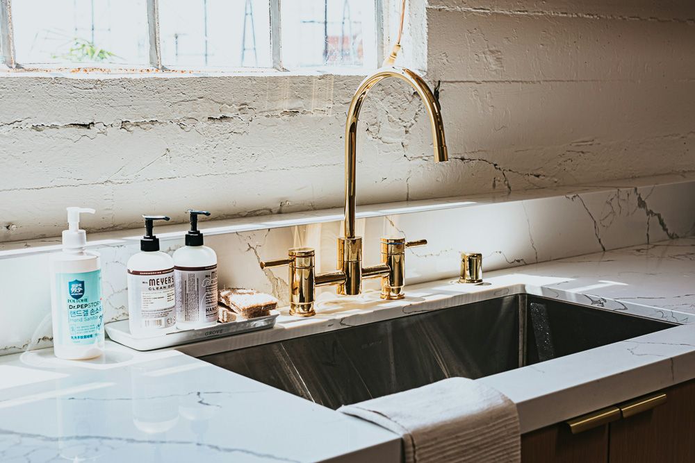 golden kitchen sink tap in a rustic kitchen