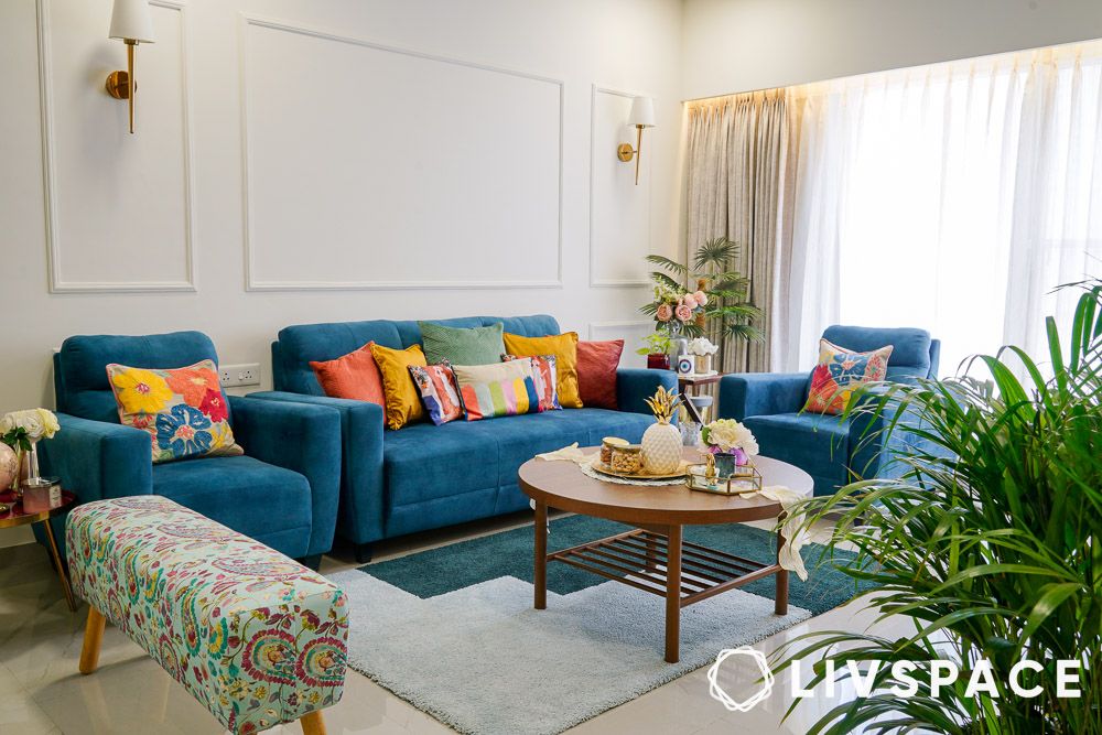 living room with wall trims and blue couch in best house design under 20 lakh