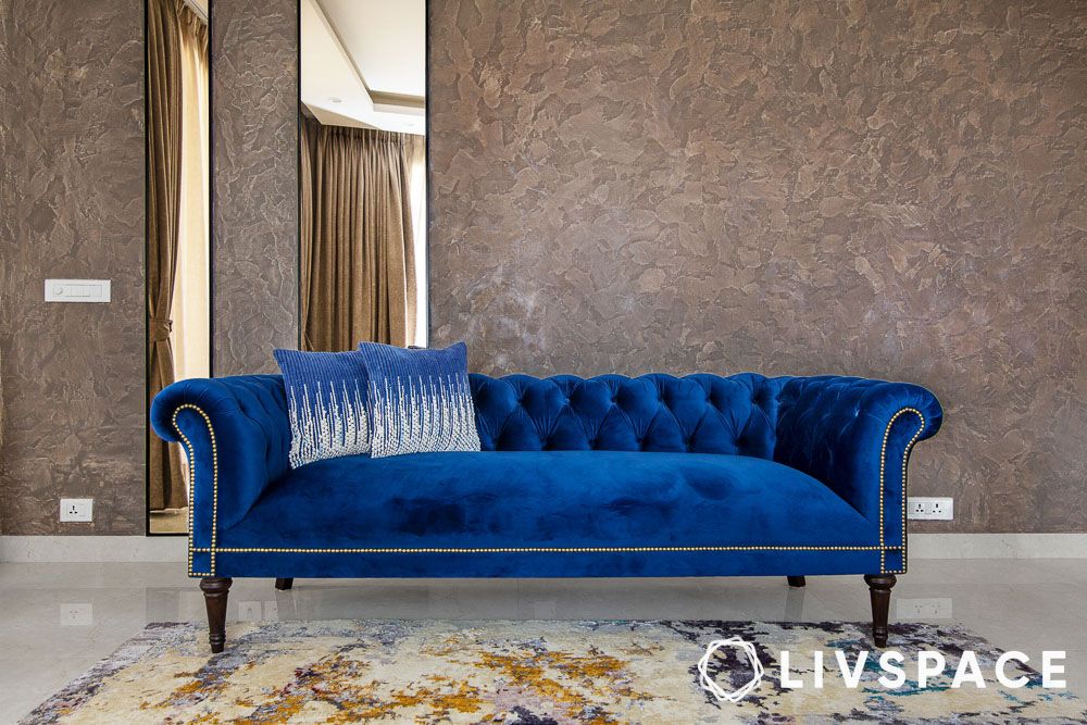 brown textured wallpaper with plush blue couch in center