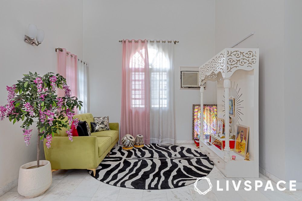 a pooja room space with couch rug and mandir