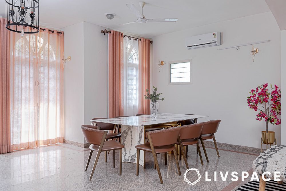 a marble dining table with leathered chairs
