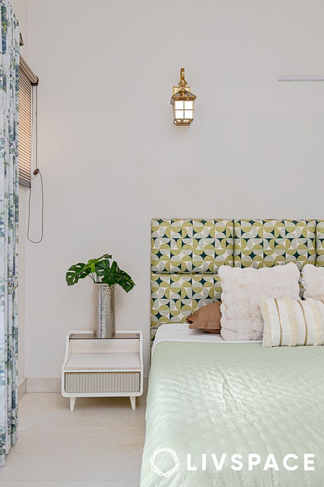 fluted bedside table next to a pastel green bed