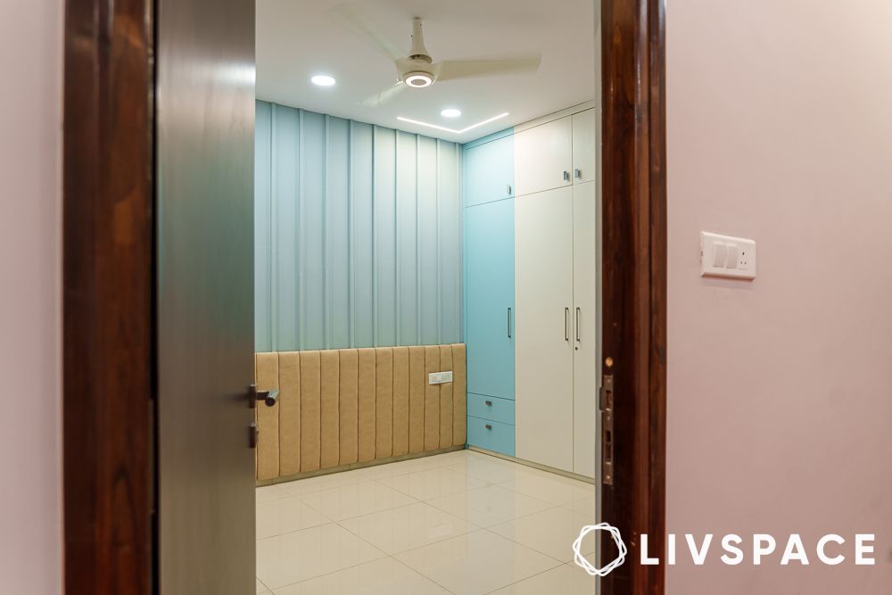 Unfurnished bedroom design with blue fluted wall panel and beige headboard design