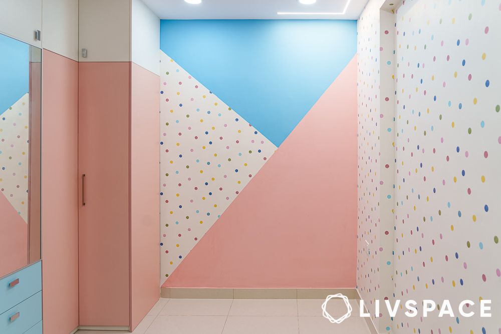White blue and pink wallpapered wall in a kids bedroom