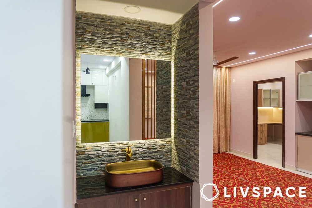 Handwash area with brown vanity cabinet and stone cladded wall