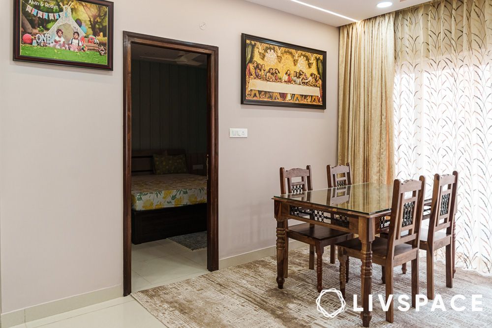 Dining room design in an open concept living room design with wooden chairs and table with glass top