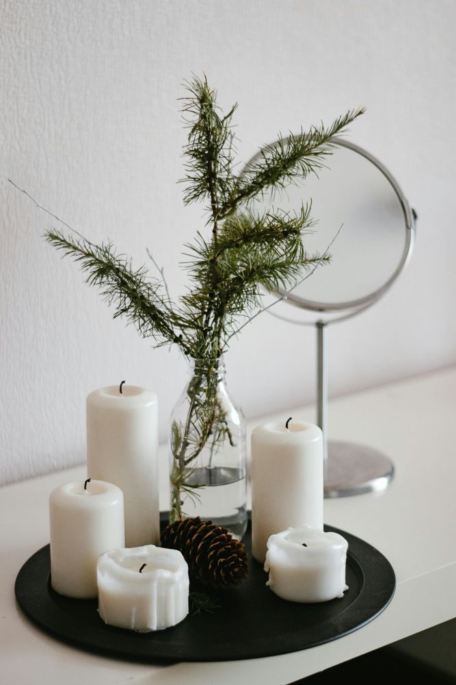white candles and pine leaves