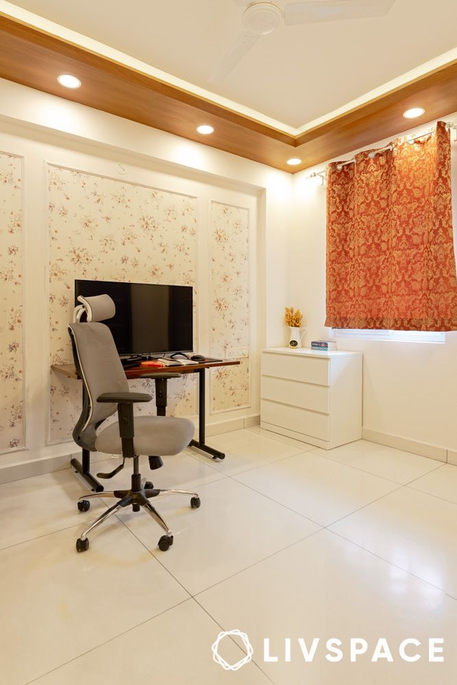 Study corner with a simple study table and floral wallpapered wainscoting
