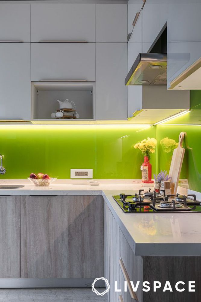 L shape modular kitchen design with a green glass backsplash