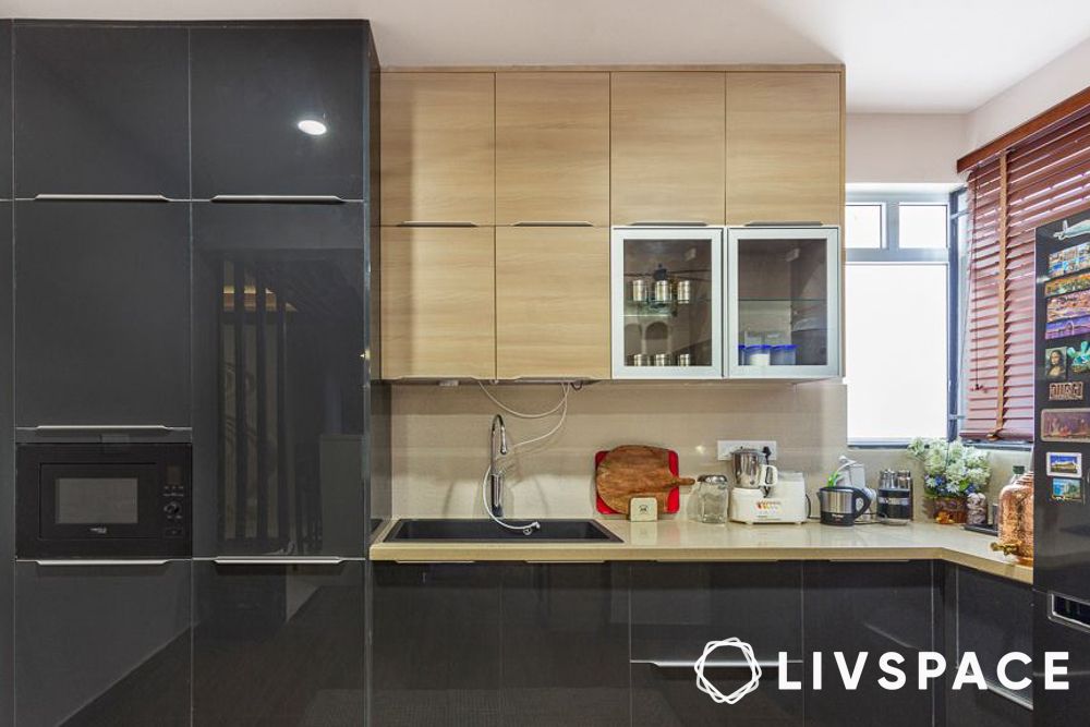 A black L shaped kitchen that makes clever use of vertical space