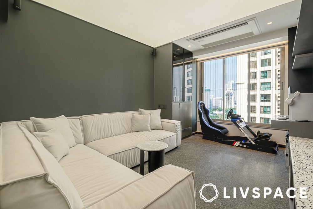 White sofa in a room furnished with gym equipments and study table