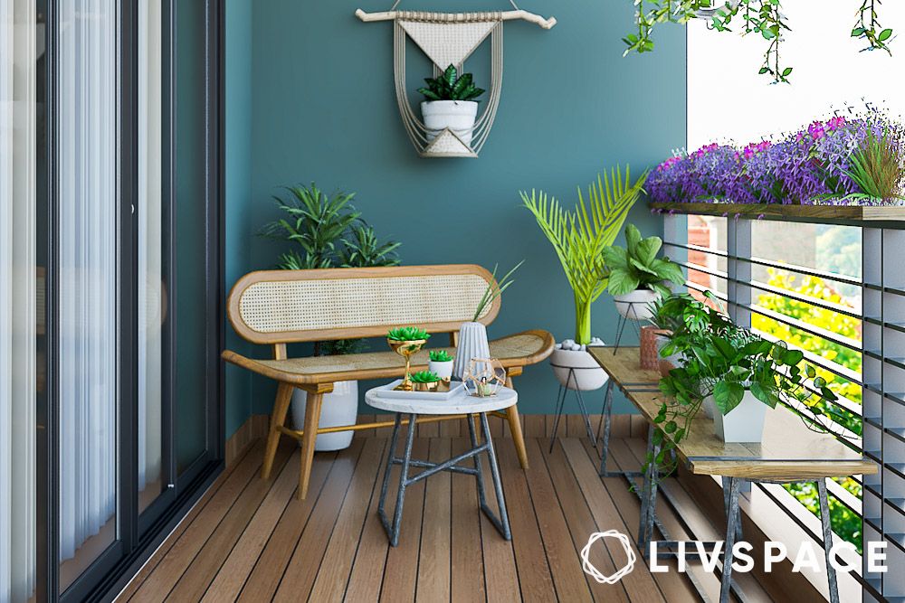 plants and rattan furniture in a balcony with teal wall