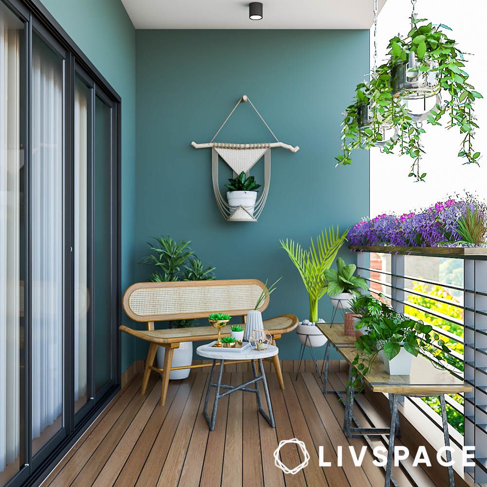 teal painted balcony with rattan furniture and plants