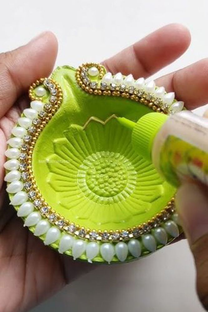green coloured kundan art diya