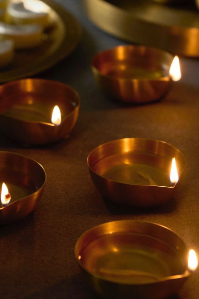 brass and copper diyas are lit up for diwali