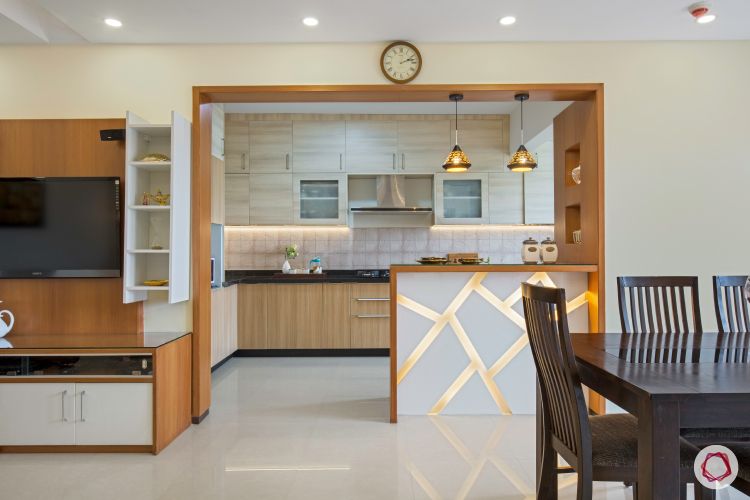 breakfast counter-pendant lighting-wooden cabinets-wooden tv unit-wooden dining table-backlit breakfast counter