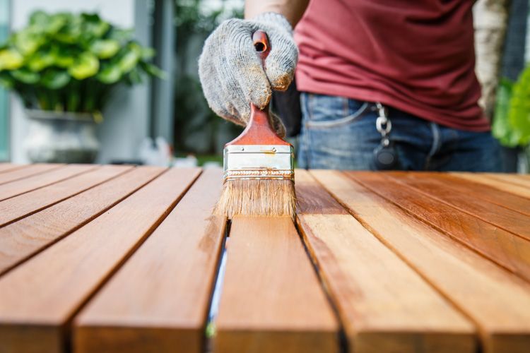 man-applying-fresh-paint-table-wooden-slats
