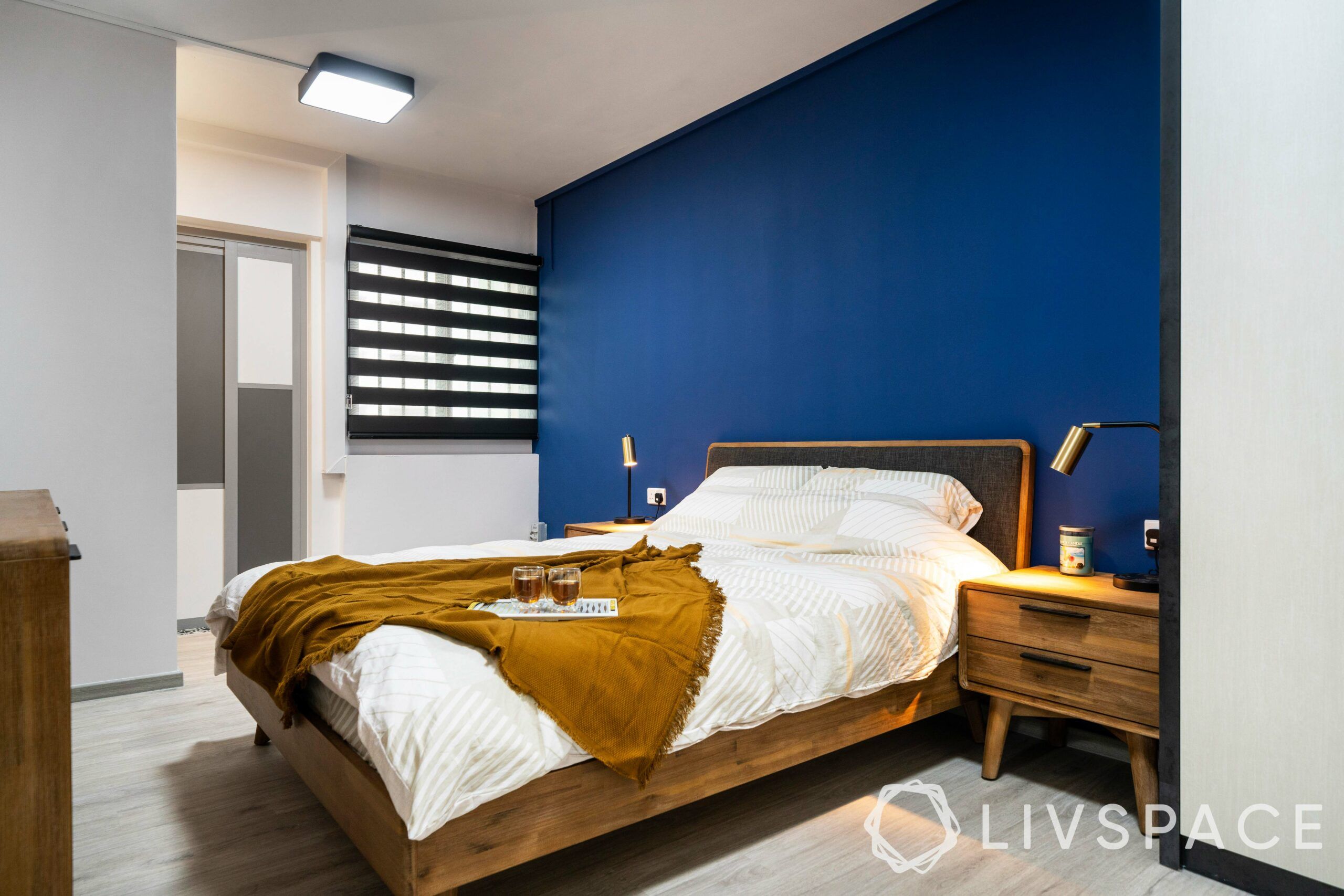wooden bed-blue wall-table lamps-side tables
