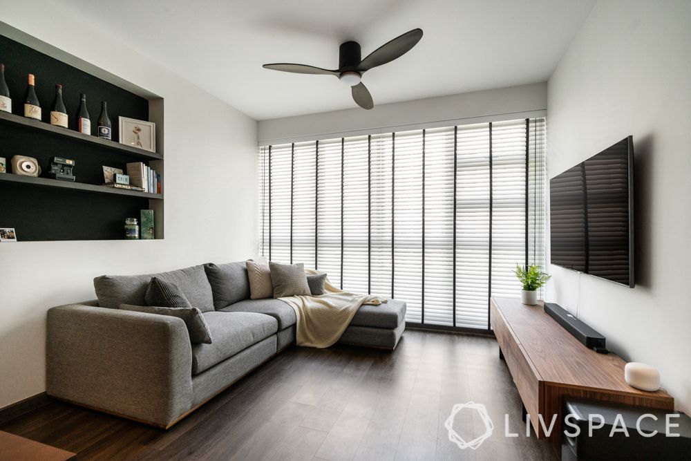 minimal-white-walls-black-shelf-grey-couch-dark-wooden-flooring