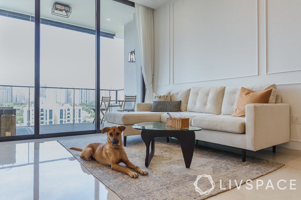 budget-homes-white-panelled-wall-white-sofa-grey-rug-balcony-glass-doors