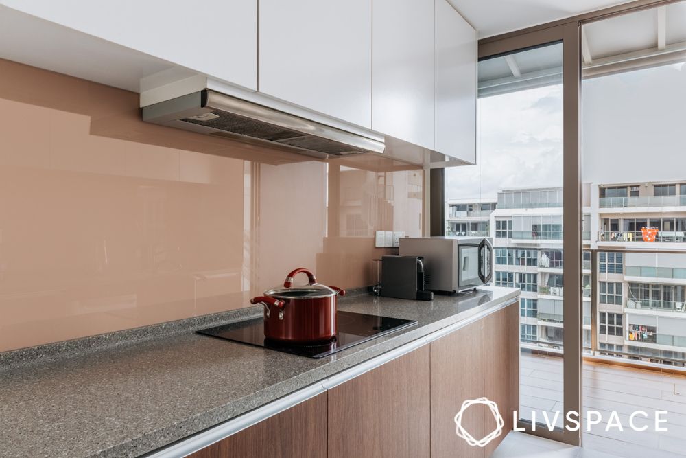 brown and white parallel kitchen with brown lacquered glass backsplash